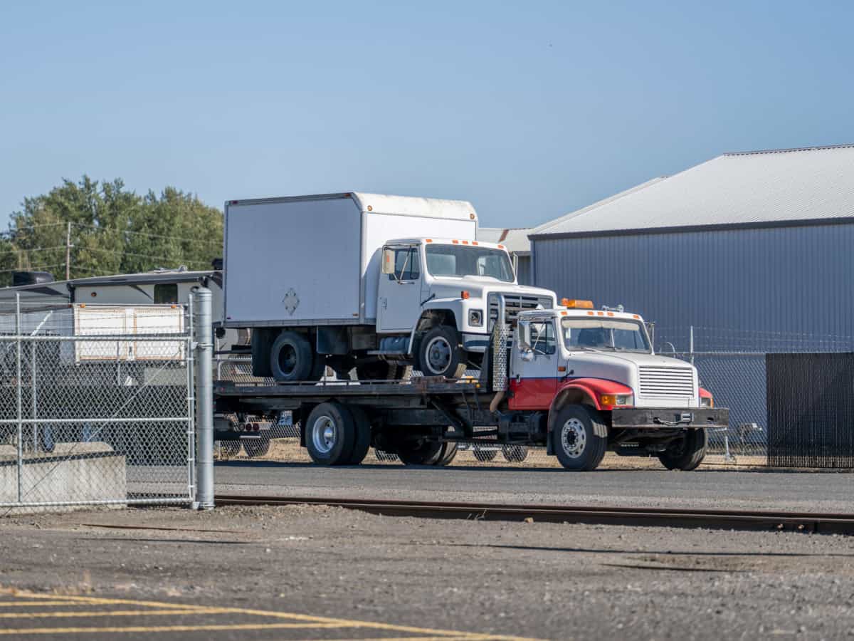 flat bed tow truck with box truck on the back