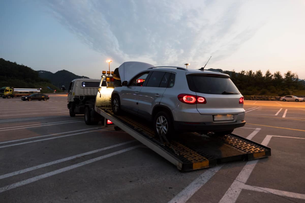 gray car being towed by a tow truck