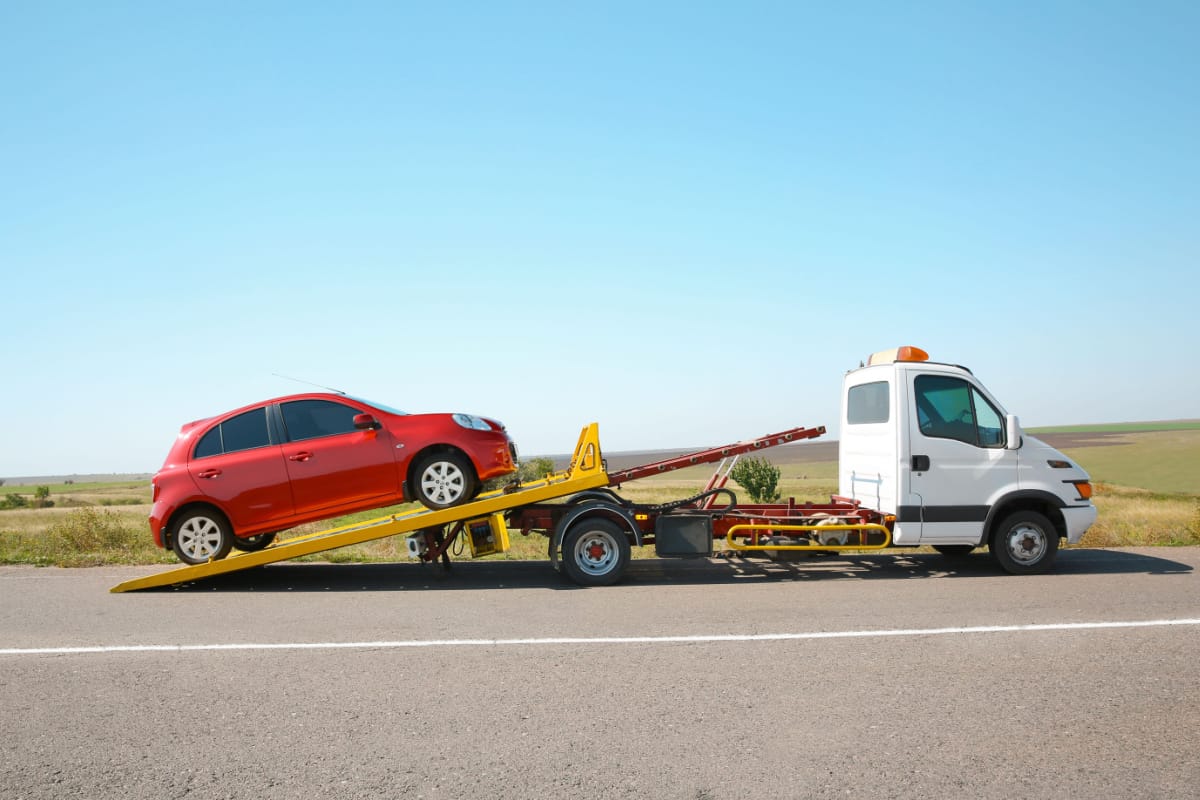 red car being put on the back of a tow truck